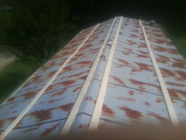Rusted metal roof panels with new wood purlins before replacement — Storm Damage Roof Repair in Burr by Roofing Brothers